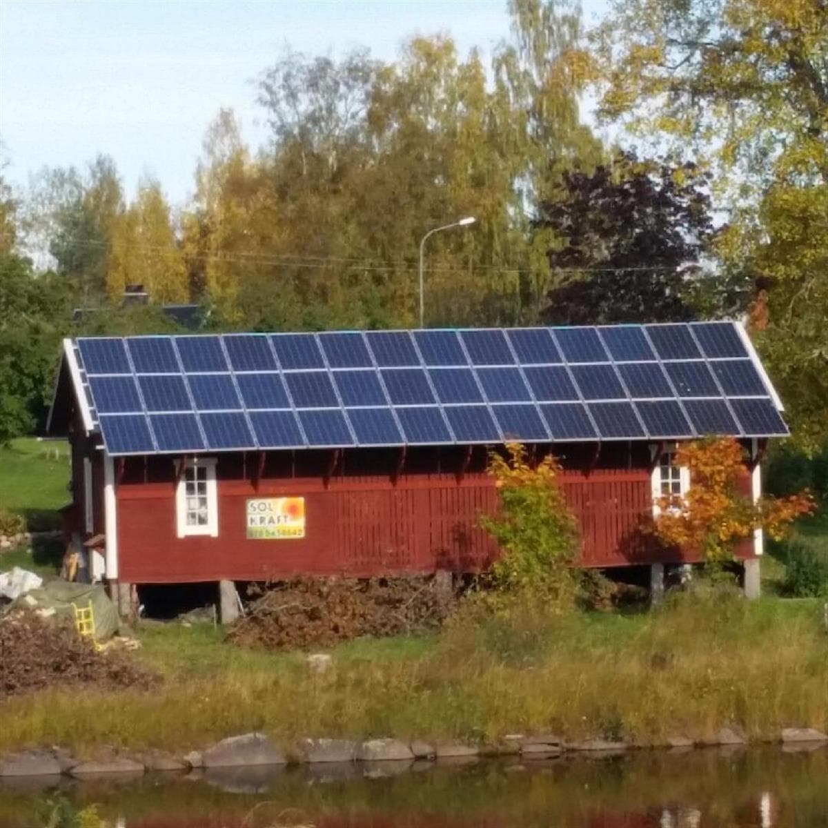 Röd byggnad vid vattnet i Alfta med en 10,5 kW solcellsanläggning