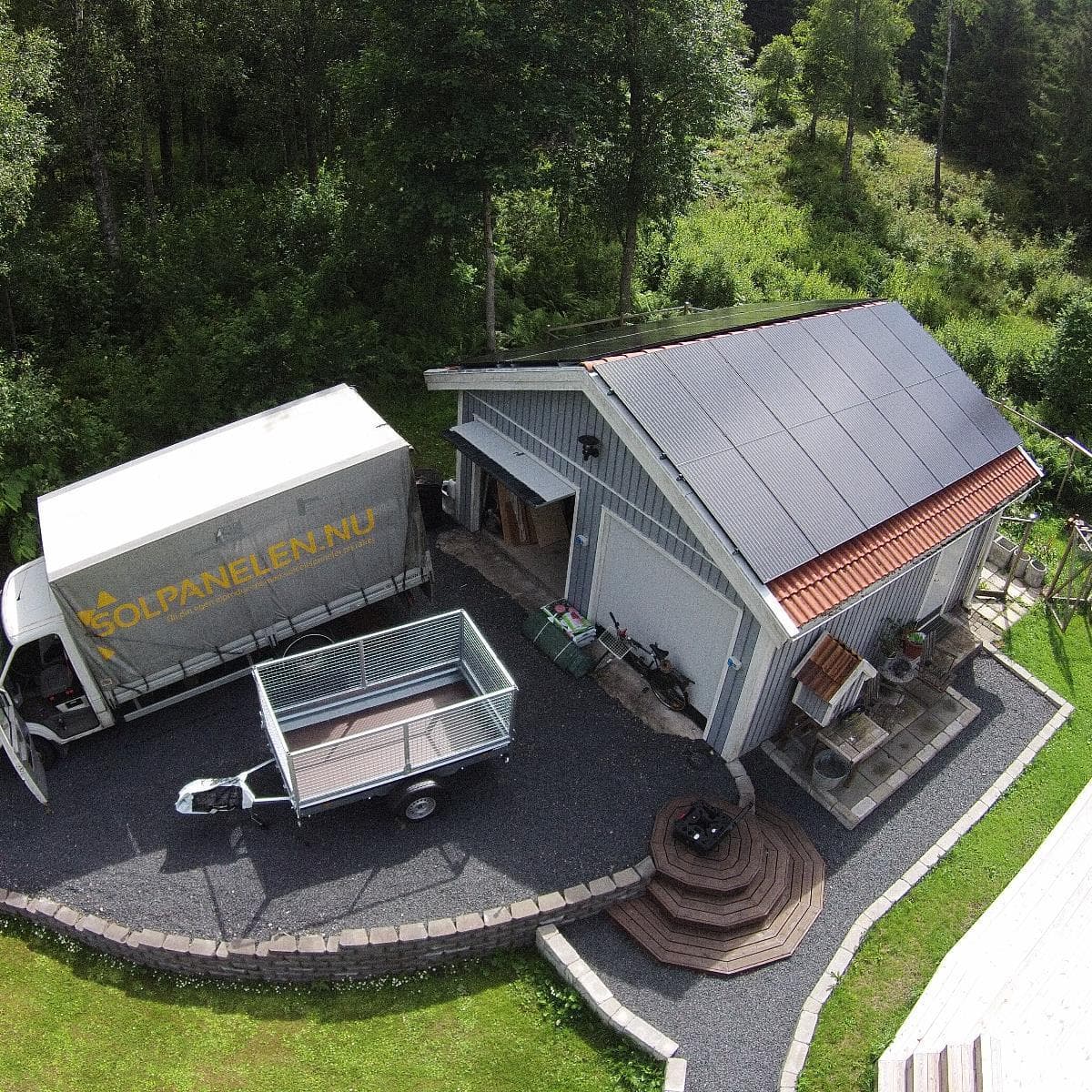 Flygfoto över garaget med 28 solpaneler och en parkerad lastbil intill
