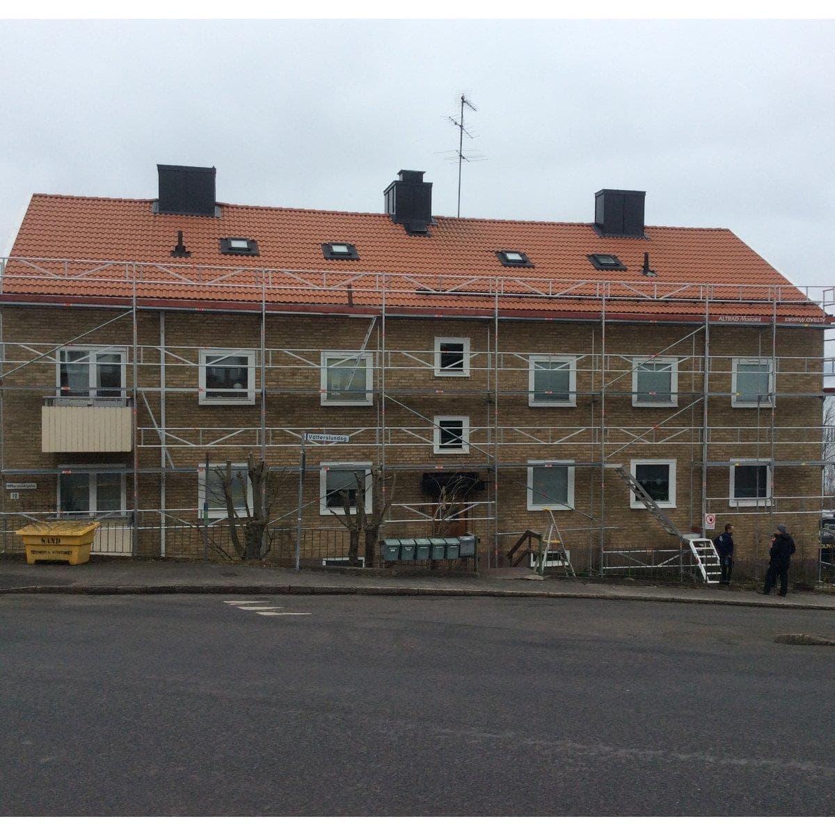 Tegelbyggnaden med byggställningar under solcellsinstallationen