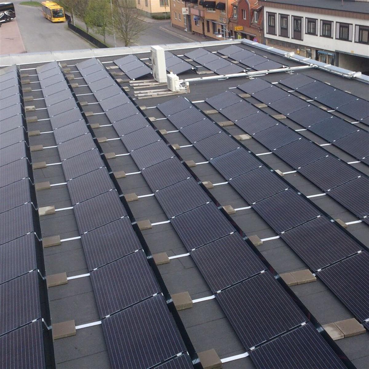 Rader med solcellspaneler på stationshusets platta tak